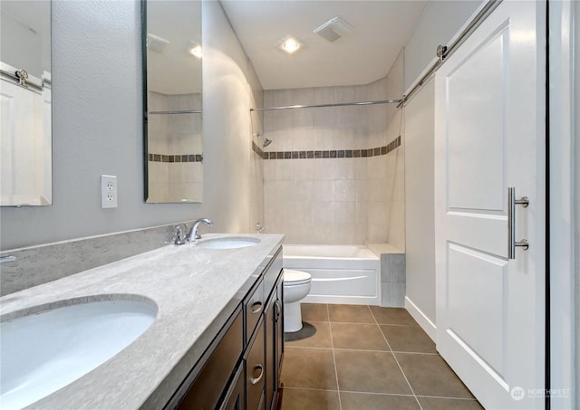 full bathroom with tiled shower / bath combo, vanity, tile patterned floors, and toilet