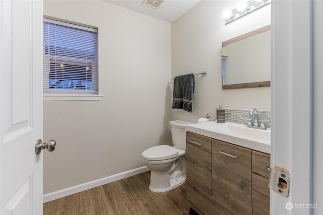 bathroom featuring hardwood / wood-style flooring, vanity, backsplash, and toilet