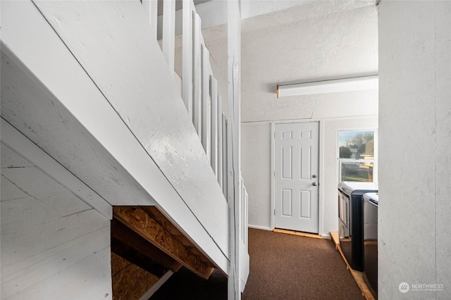 stairway with carpet floors and washing machine and clothes dryer