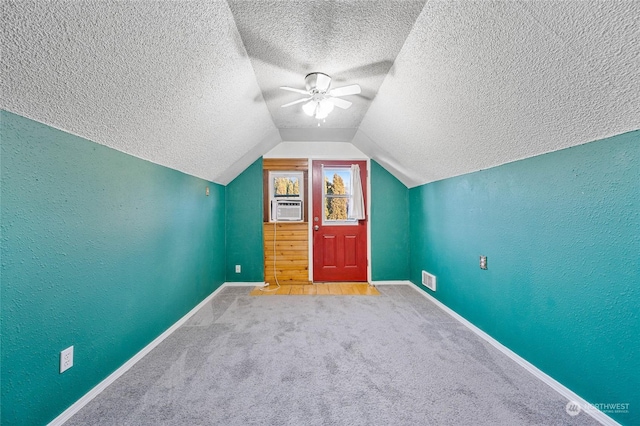 bonus room featuring vaulted ceiling, cooling unit, carpet, ceiling fan, and a textured ceiling