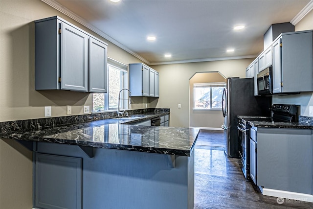 kitchen featuring sink, a kitchen breakfast bar, kitchen peninsula, crown molding, and black / electric stove