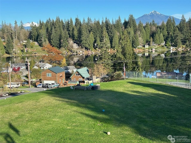 view of property's community featuring a water and mountain view and a lawn