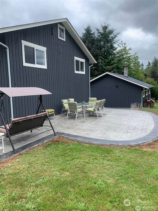 rear view of property featuring a yard and a patio area