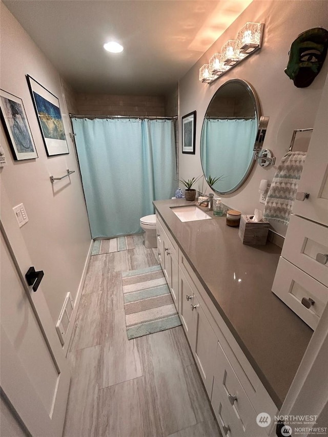 bathroom with a shower with curtain, vanity, toilet, and hardwood / wood-style floors