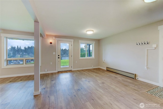 entryway featuring a baseboard heating unit, wood finished floors, and baseboards