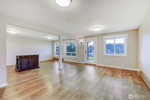 entryway with light wood finished floors, a baseboard radiator, and baseboards