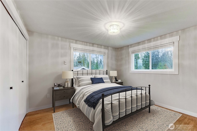 bedroom featuring light wood-style floors, a closet, and baseboards