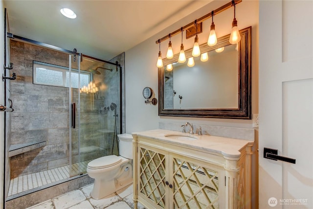 bathroom with vanity, a shower stall, and toilet