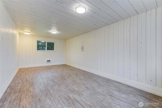 finished basement with wood ceiling, baseboards, and wood finished floors