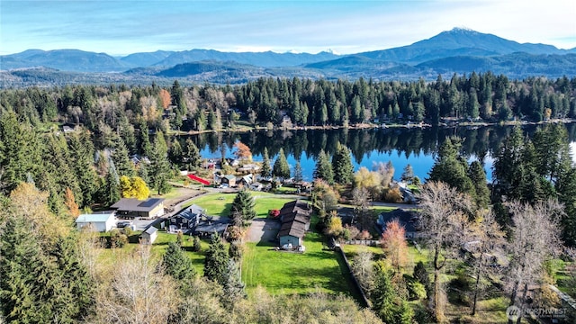 aerial view with a wooded view and a water and mountain view