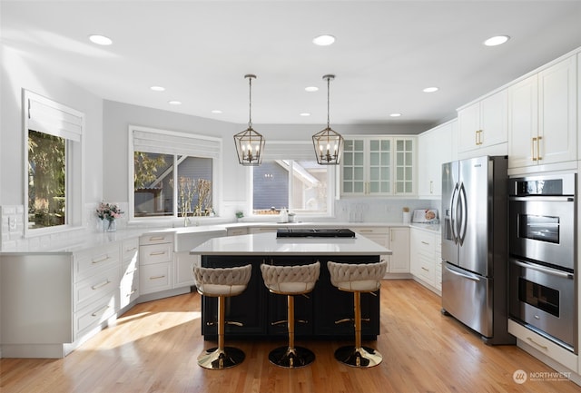 kitchen with a kitchen island, white cabinetry, appliances with stainless steel finishes, and a kitchen breakfast bar