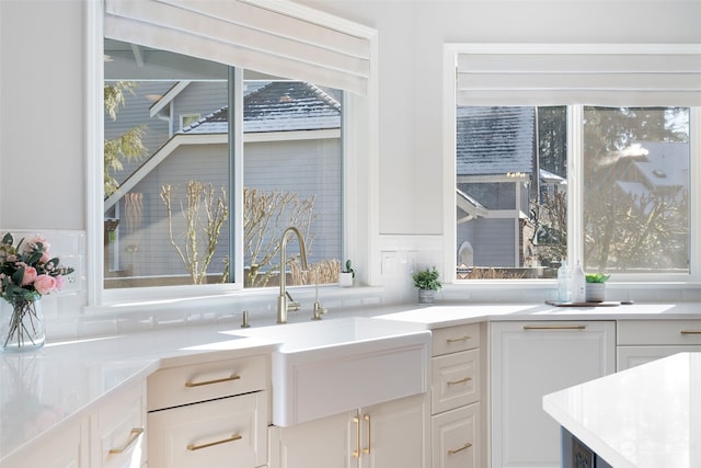 kitchen featuring white cabinetry and sink