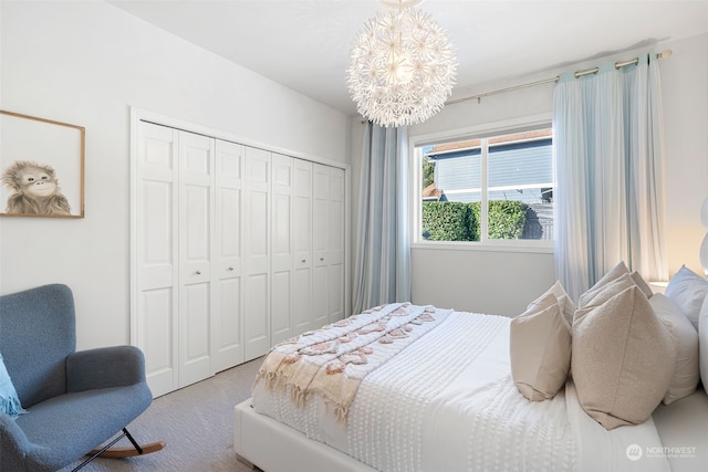 carpeted bedroom featuring a notable chandelier and a closet