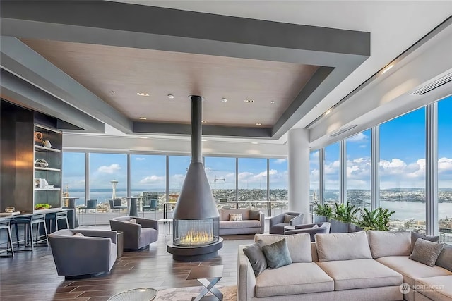 interior space with hardwood / wood-style floors, a wealth of natural light, a water view, and a wood stove