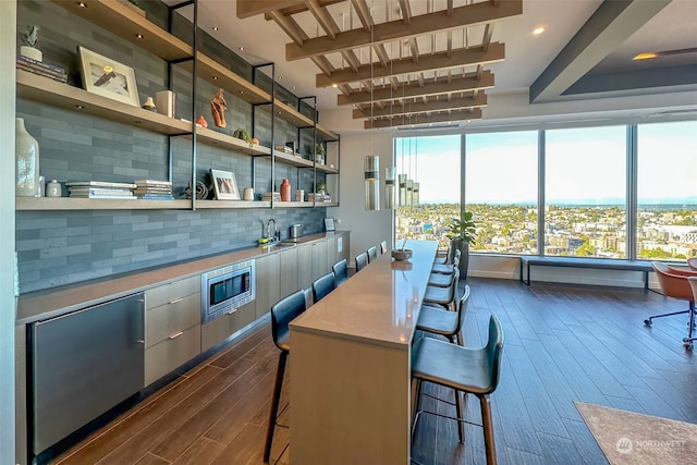 bar with stainless steel microwave, tasteful backsplash, and dark hardwood / wood-style floors