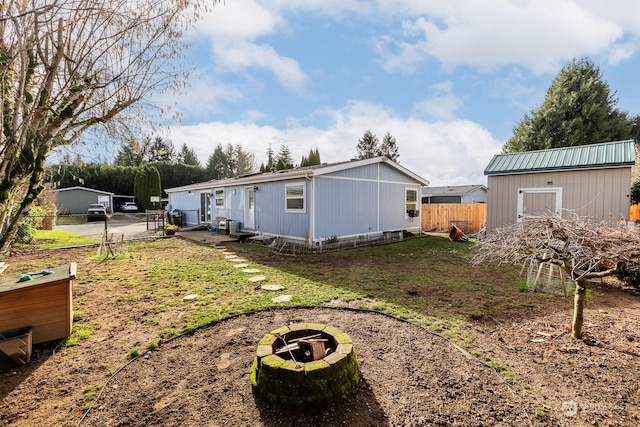 view of side of home with an outdoor fire pit and a lawn