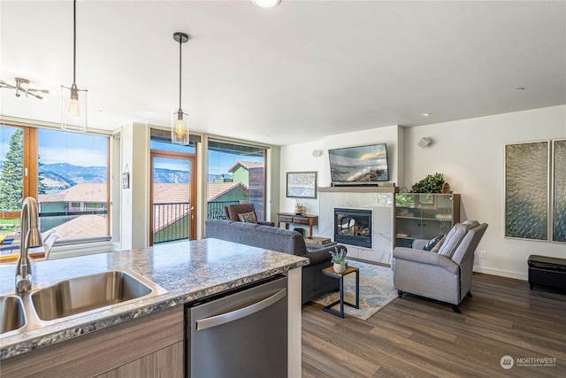 kitchen featuring sink, decorative light fixtures, stainless steel dishwasher, a mountain view, and a high end fireplace