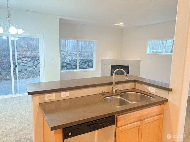 kitchen with sink, carpet flooring, light brown cabinetry, decorative light fixtures, and stainless steel dishwasher