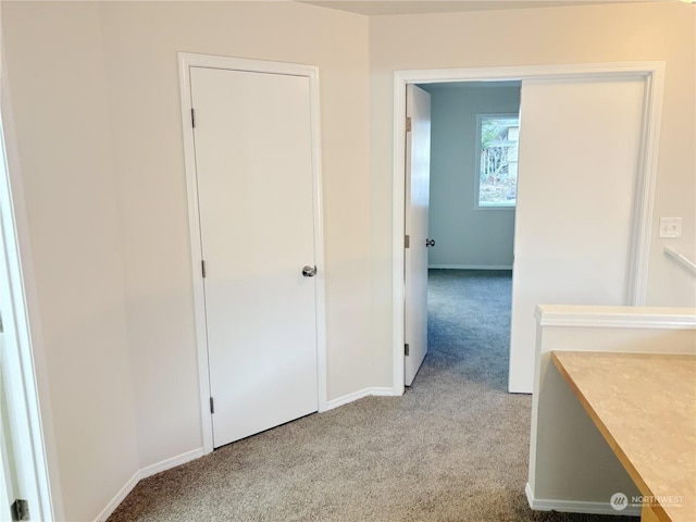 hallway featuring light colored carpet