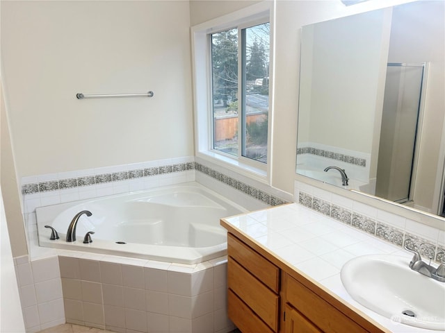 bathroom with vanity and shower with separate bathtub