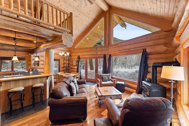 living room with beamed ceiling, a healthy amount of sunlight, light hardwood / wood-style flooring, and wooden ceiling