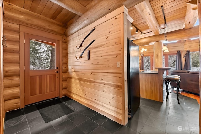 interior space featuring wood ceiling, track lighting, beamed ceiling, and wood walls