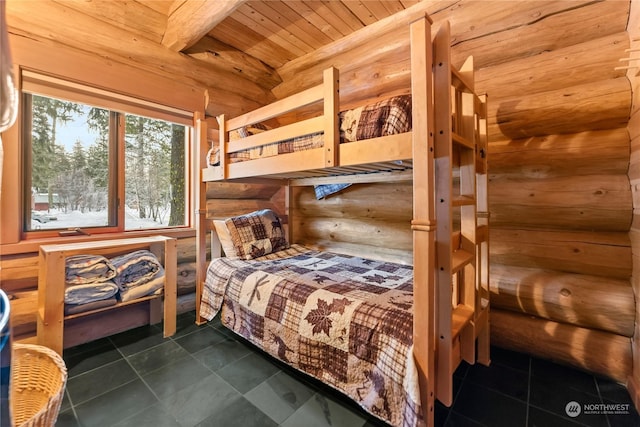 bedroom with wood ceiling, dark tile patterned flooring, and beamed ceiling