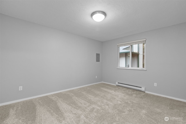 spare room featuring carpet floors, a textured ceiling, and a baseboard heating unit