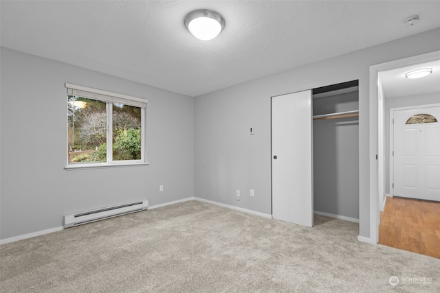 unfurnished bedroom with a baseboard radiator, light colored carpet, a closet, and a textured ceiling