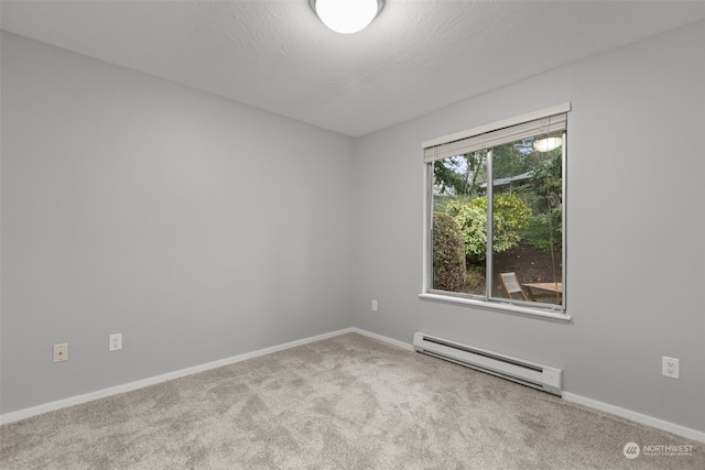 spare room with a baseboard heating unit, a textured ceiling, and carpet flooring