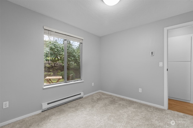 spare room with a baseboard radiator, a textured ceiling, and carpet flooring