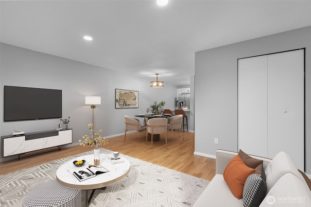 living room featuring recessed lighting, light wood-type flooring, and baseboards