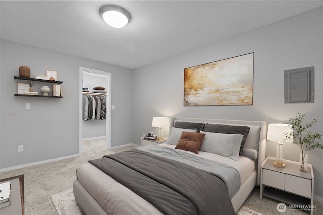 bedroom featuring a spacious closet, electric panel, baseboards, and carpet floors