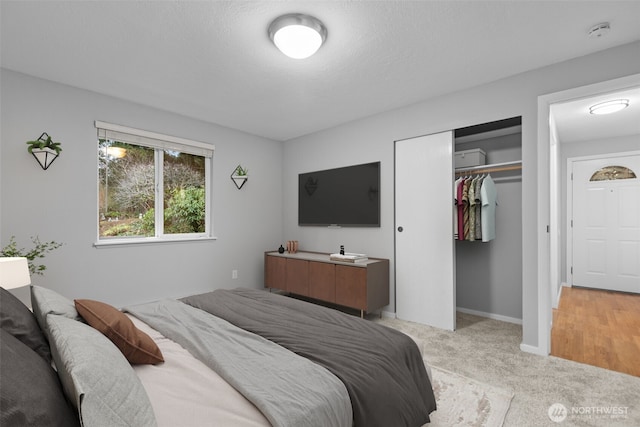 bedroom with light colored carpet, a closet, and baseboards