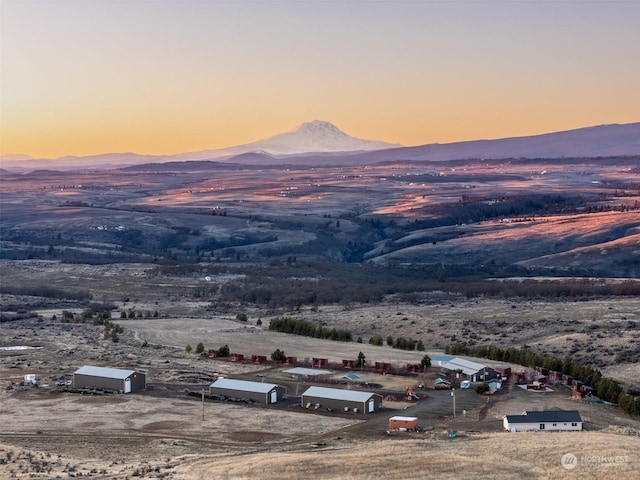 aerial view at dusk featuring a mountain view