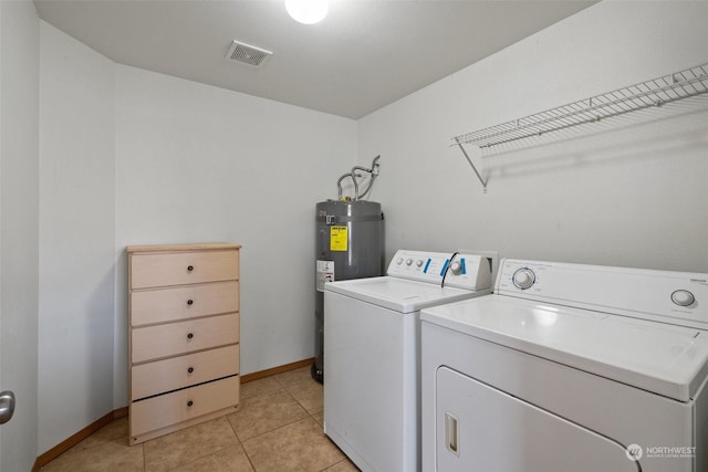 laundry area featuring light tile patterned flooring, independent washer and dryer, and water heater