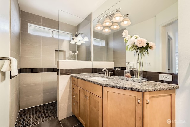 bathroom with vanity, a tile shower, and tile patterned floors