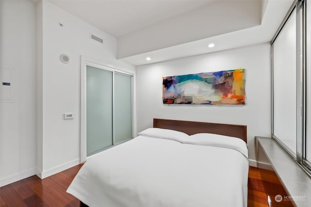 bedroom featuring dark wood-type flooring and a closet