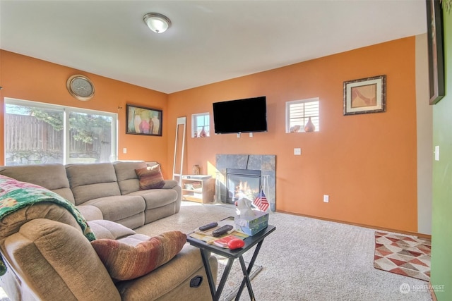 carpeted living room with plenty of natural light and a high end fireplace