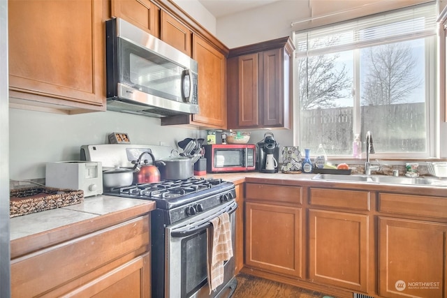 kitchen featuring stainless steel appliances, tile counters, sink, and plenty of natural light