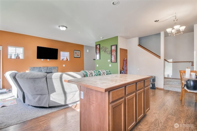 kitchen with a notable chandelier, a center island, hanging light fixtures, and light hardwood / wood-style flooring