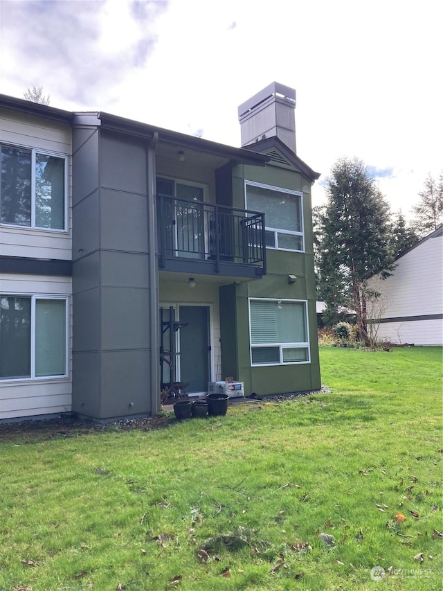 rear view of property with a lawn