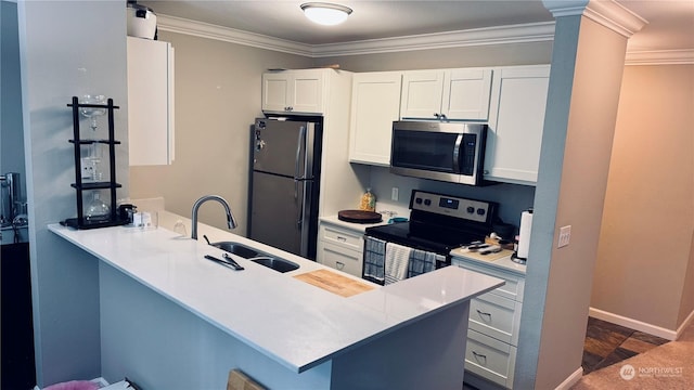 kitchen featuring a peninsula, a sink, white cabinetry, light countertops, and appliances with stainless steel finishes