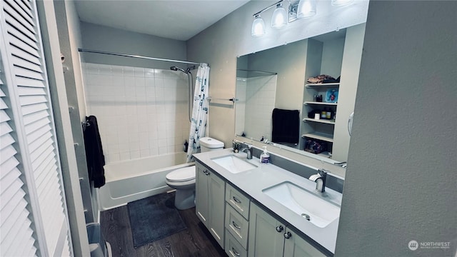 full bath featuring wood finished floors, shower / bath combo, a sink, and toilet