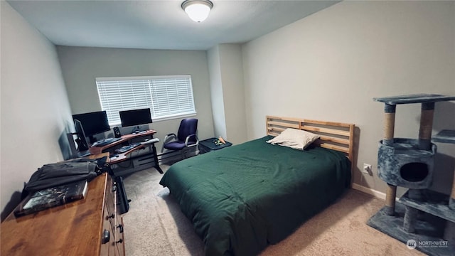 bedroom featuring light carpet and baseboards