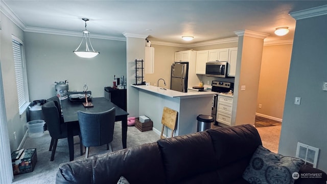 kitchen featuring white cabinetry, kitchen peninsula, pendant lighting, light colored carpet, and stainless steel appliances