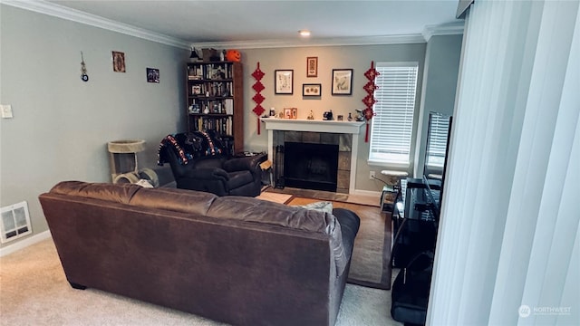 living room featuring ornamental molding, carpet flooring, and a tile fireplace