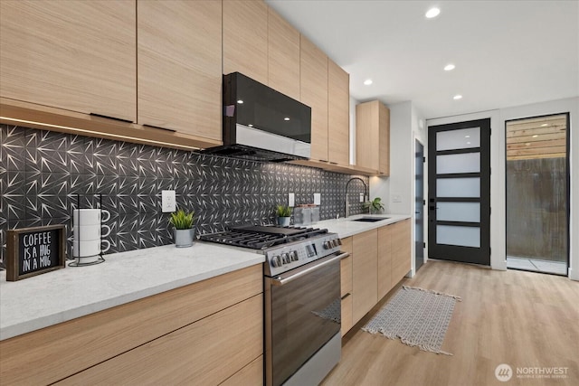 2405 E Fir St B/Adu, Unit B/Adu Seattle, WA 98122 - kitchen featuring sink, light wood-type flooring, light brown cabinets, appliances with stainless steel finishes, and backsplash