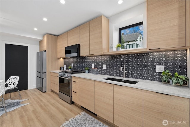 2405 E Fir St B/Adu, Unit B/Adu Seattle, WA 98122 - kitchen with light brown cabinetry, sink, tasteful backsplash, stainless steel appliances, and light hardwood / wood-style floors