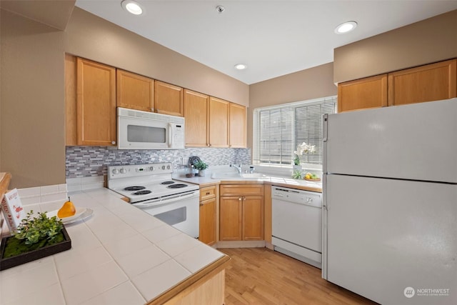 kitchen with tasteful backsplash, sink, tile countertops, and white appliances